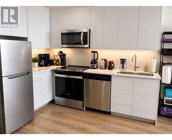 A modern kitchen with stainless steel appliances and white cabinets.