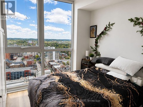 A bedroom with a large bed and a view of the city.