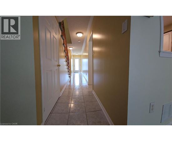A hallway with tiled floors and white walls.