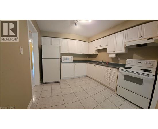 A kitchen with white appliances and cabinets.