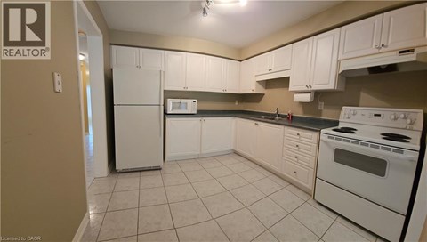 A kitchen with white appliances and cabinets.