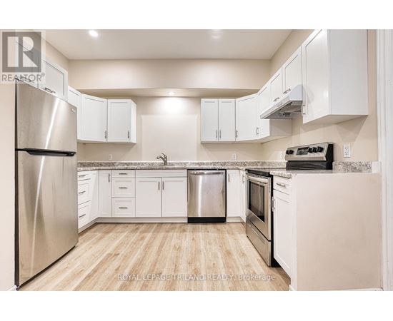 A kitchen with white cabinets and a stainless steel refrigerator.