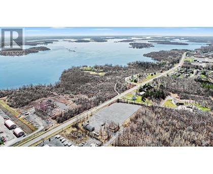 An aerial view of a construction site with a body of water in the background.