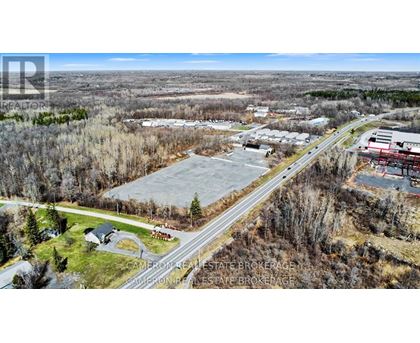 A real estate brokerage office is located in a wooded area with a road passing by.