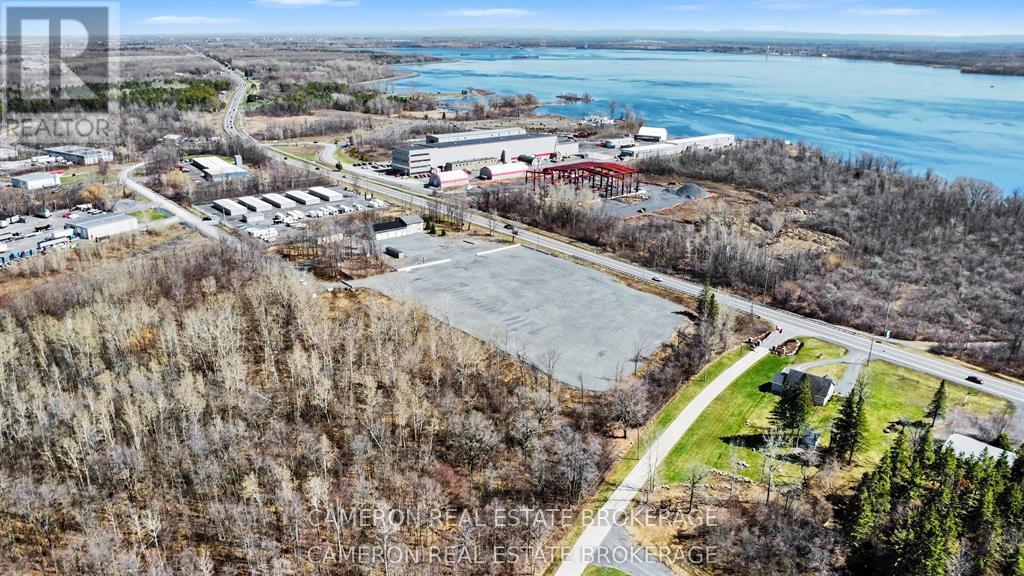 A real estate company is advertising a property with an aerial view of a parking lot, buildings, and a body of water.