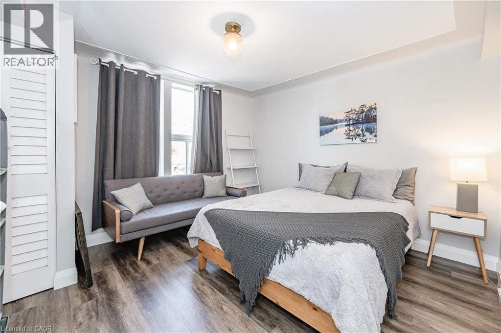 A bedroom with a bed, a bench, and a nightstand.