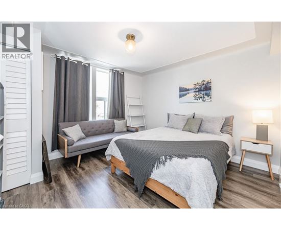 A bedroom with a bed, a bench, and a nightstand.