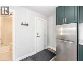 A kitchen with a stainless steel refrigerator and green cabinets.