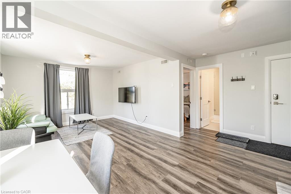 A living room with a white table and grey chairs.
