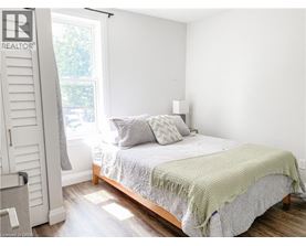 A bedroom with a bed covered in a green blanket.