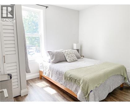 A bedroom with a bed covered in a green blanket.