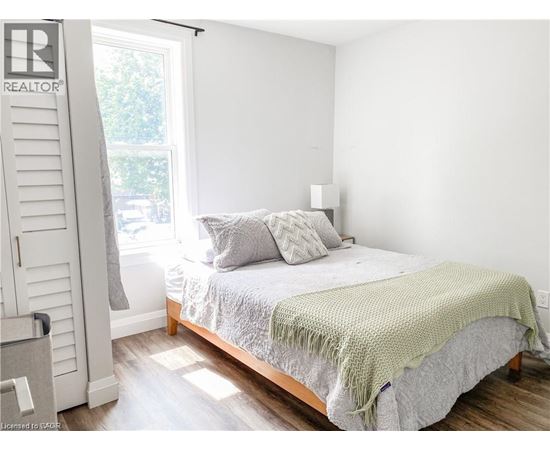 A bedroom with a bed covered in a green blanket.