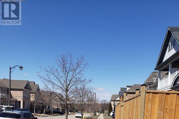 A residential street with houses on both sides and a clear blue sky.