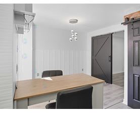 A conference room with a wooden table and chairs.