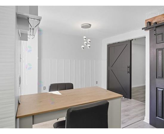A conference room with a wooden table and chairs.