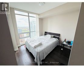 A bedroom with a large bed and a view of the city.