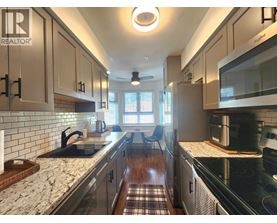 A kitchen with a black counter top and white cabinets.