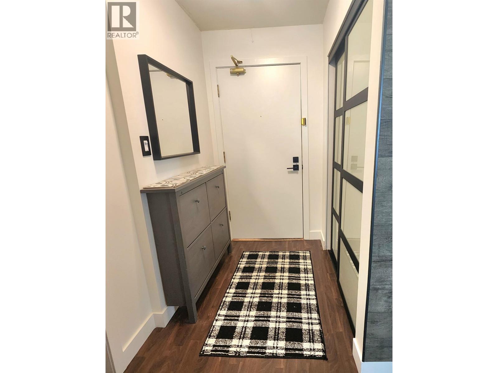 A hallway with a black and white checkered rug on the floor.