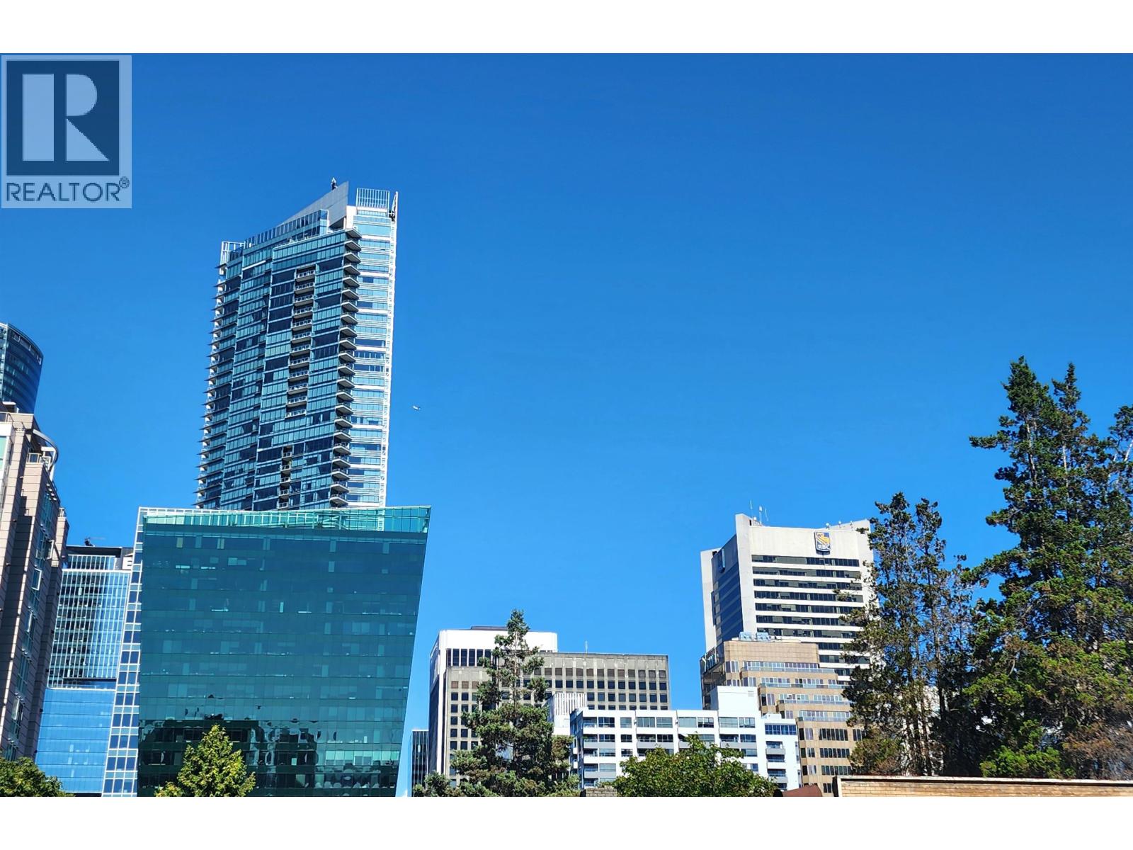 A cityscape with a blue sky and buildings of various heights.