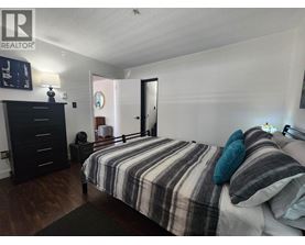 A bedroom with a bed, dresser, and mirror.