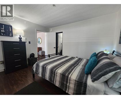 A bedroom with a bed, dresser, and mirror.