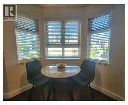 A dining room with a table and chairs.