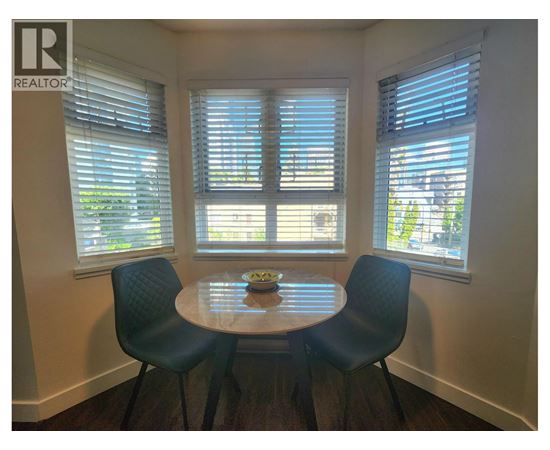A dining room with a table and chairs.