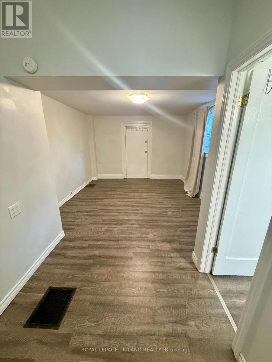 A hallway with a wooden floor and white walls.