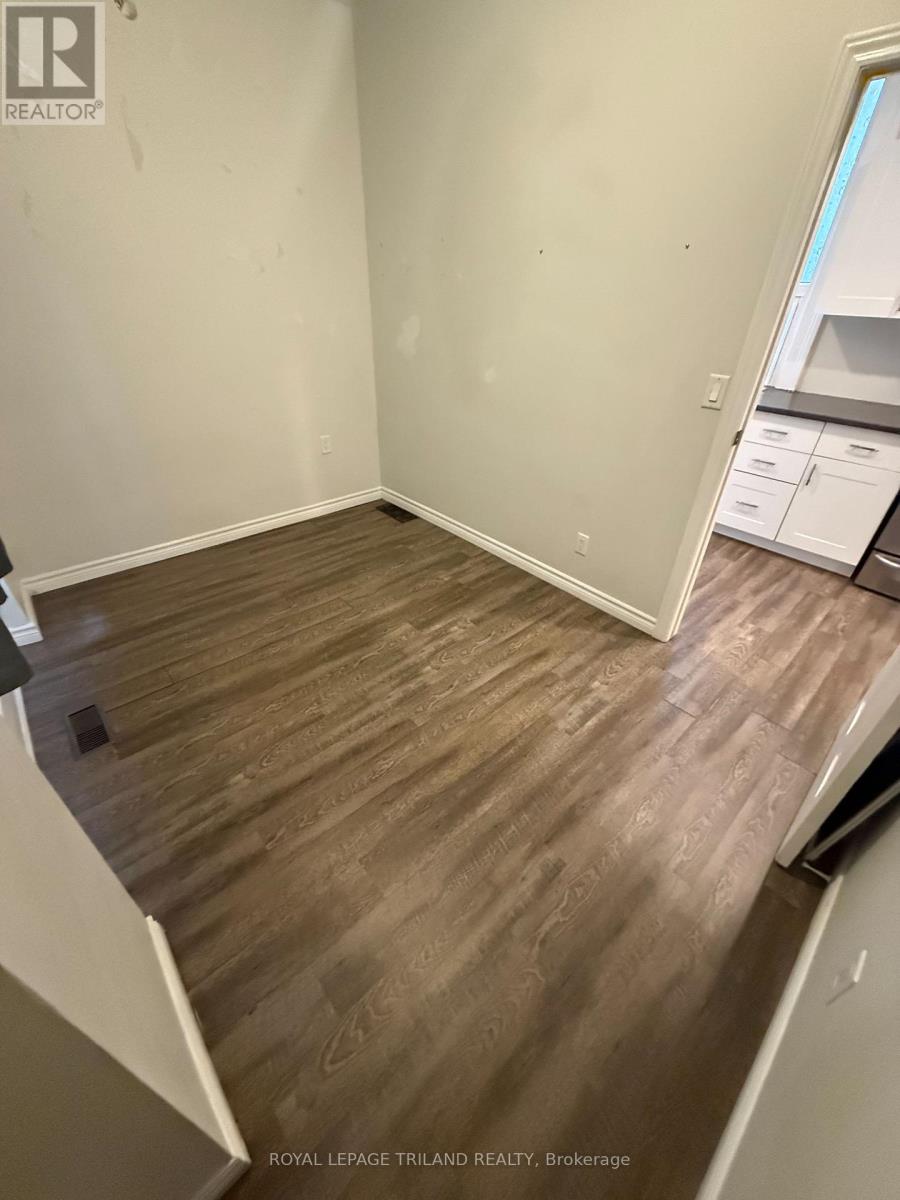 A room with wooden flooring and white walls.