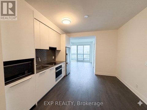 A kitchen with white cabinets and black appliances is shown.