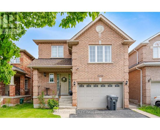 A house with a garage and a driveway in front of it.