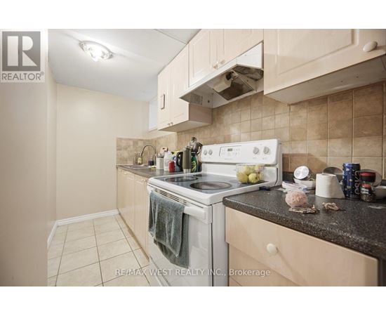 A kitchen with a white stove top oven and a white range hood.