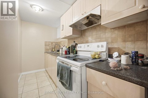 A kitchen with a white stove top oven and a white range hood.