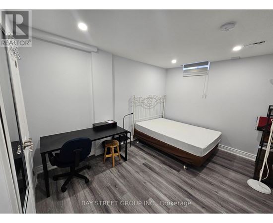 A room with a bed, desk, and chair.