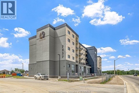 A large grey building with a logo on the top left corner and the number 733 on the right side.