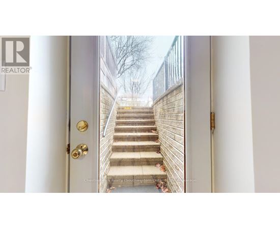 A white door with a gold handle and a set of stairs leading up to it.