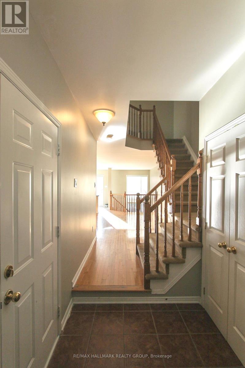 A hallway with a staircase and a light on the wall.