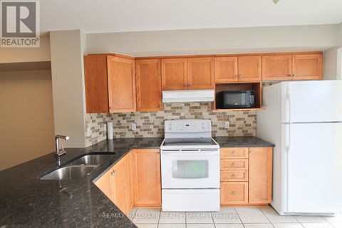 A kitchen with wooden cabinets and a white fridge.