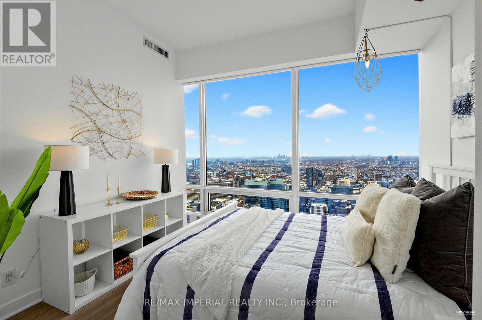 A bedroom with a large bed and a view of the city.