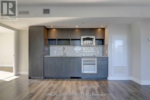 A modern kitchen with dark wood cabinets and a stainless steel oven.