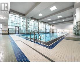 A large indoor swimming pool with a blue and white tile border.