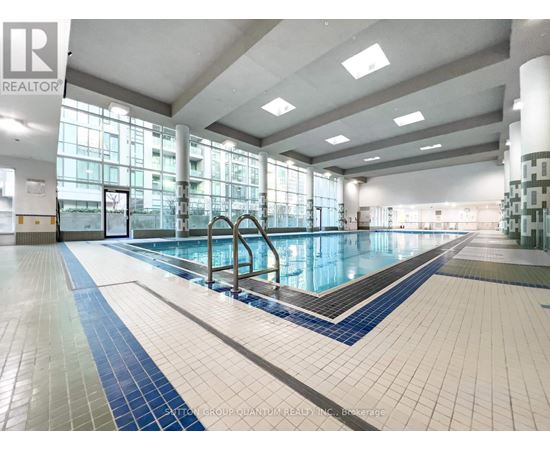 A large indoor swimming pool with a blue and white tile border.