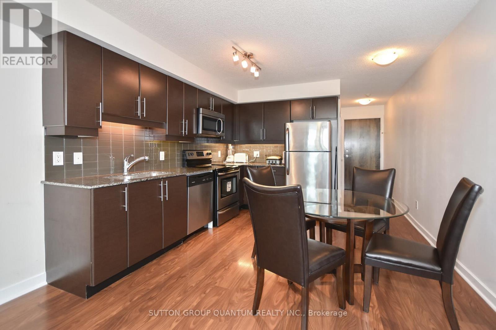A kitchen with brown cabinets and a glass table.