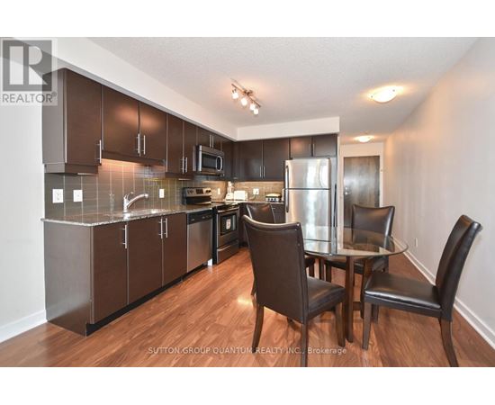 A kitchen with brown cabinets and a glass table.
