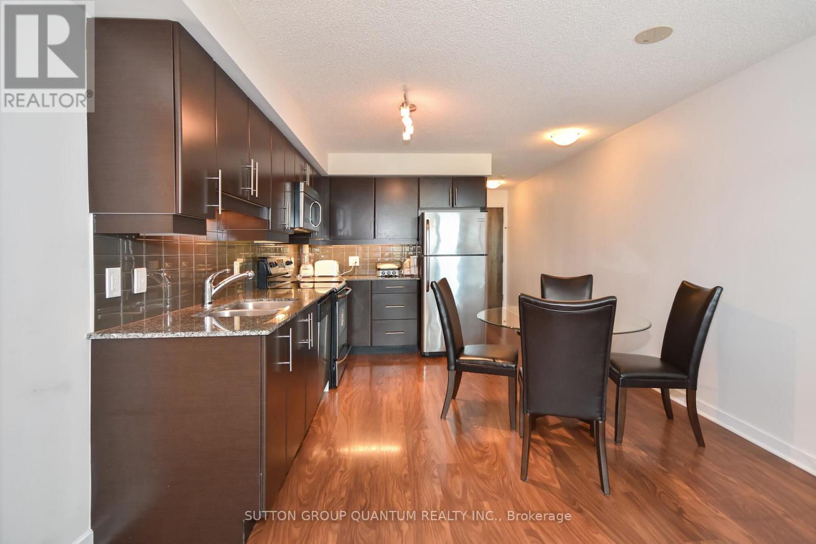 A modern kitchen with dark wood floors and a copper range hood.