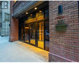 The entrance to a building with a glass door and a brick wall.