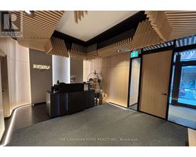 A reception area with a black counter and a person standing behind it.