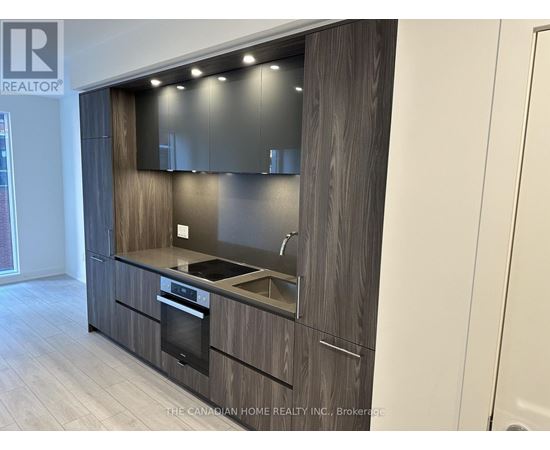 A modern kitchen with dark wood cabinets and stainless steel appliances.