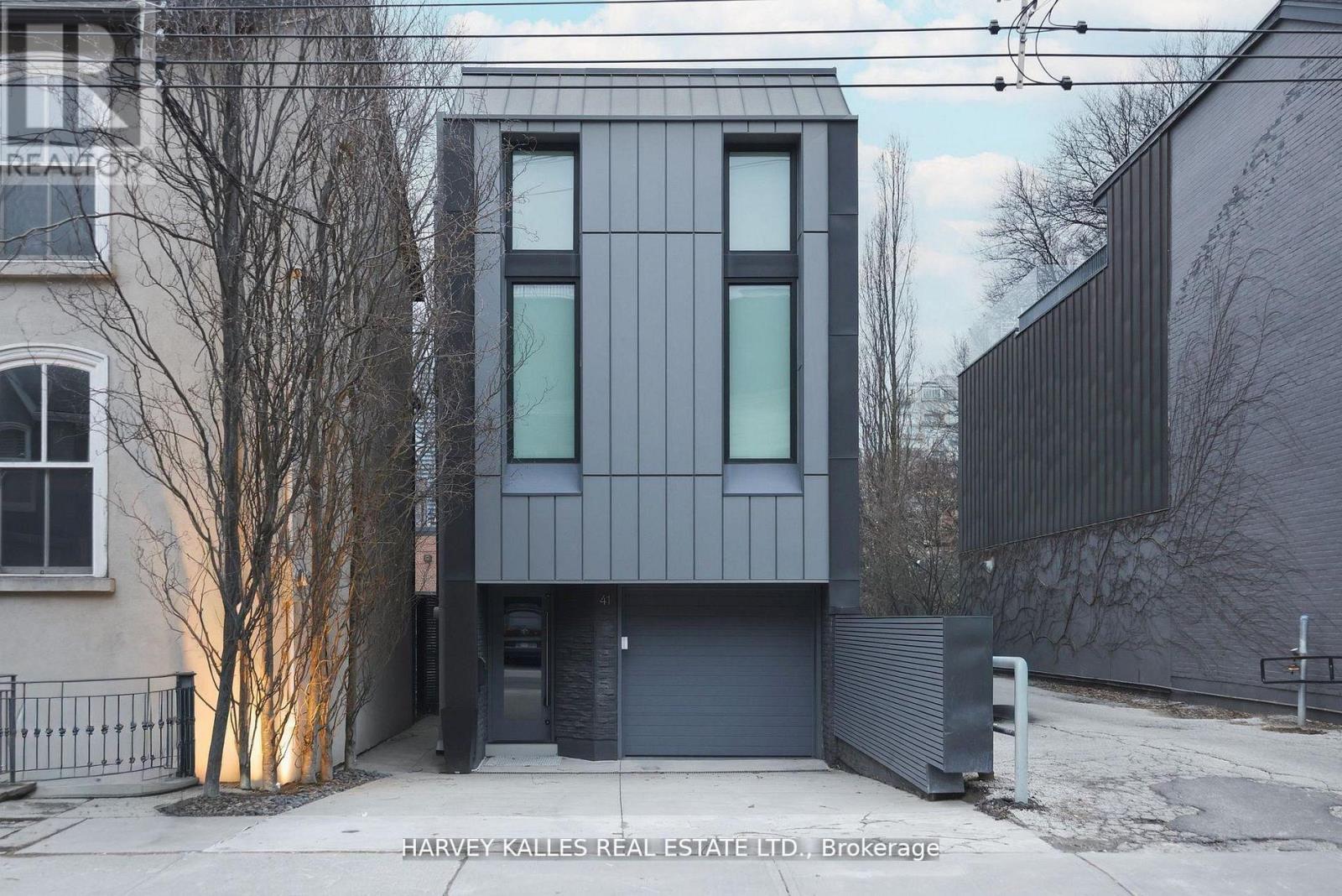 A modern house with a grey facade is shown in the image.