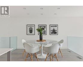 A dining room with a table and chairs and pictures on the wall.